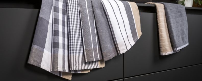 Graubeige Küchenhandtücher hängen von einer Arbeitsplatte herunter